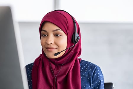 Frau mit Headset arbeitet an einem Computer