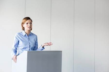 Frau hinter Rednerpult