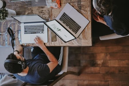 Mitarbeiter ist am Laptop und informiert sich ueber die besten Chatbots