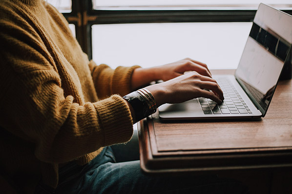 Frau beschäftigt sich mit unterschiedlichen LinkBuilding-Strategien am Laptop
