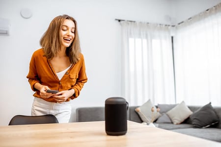 Frau spricht mit Sprachassistent symbolisierend für Natural Language Processing