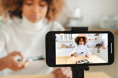 Frau filmt YouTube-Shorts mit Smartphone