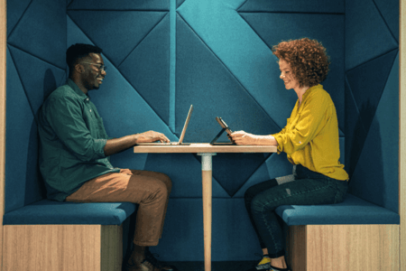Frau und Mann sitzen sich gegenüber und führen A/B-Testing durch