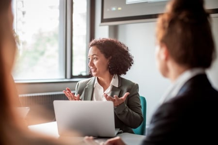 Frau sitzt im Meeting und bespricht den B2B-Vertrieb mit ihrem Team