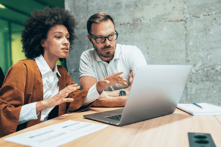 Mann und Frau am Laptop setzen Canonical Tag auf Webseite