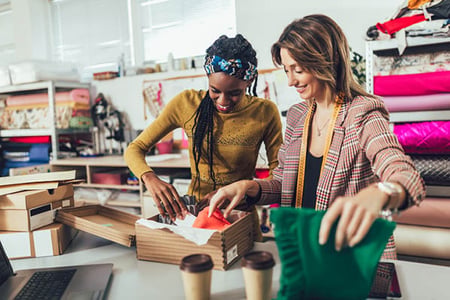 Zwei Frauen verpacken Produkte für Verkauf über E-Commerce