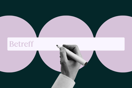 Person formuliert E-Mail-Betreff am Laptop