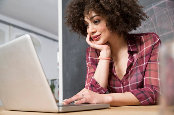 Frau schaut auf Laptop und arbeitet mit Excel VBA