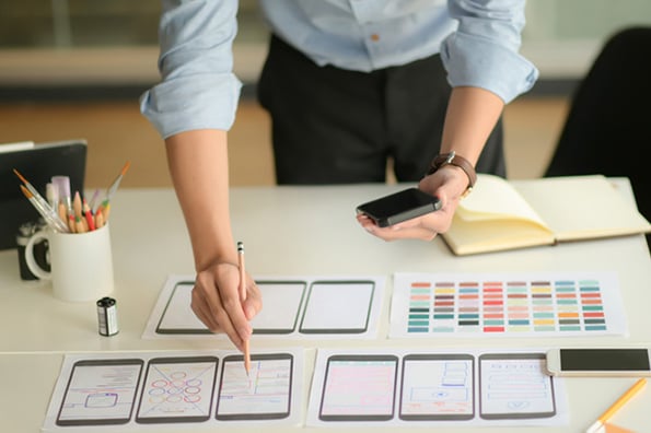 Frau arbeitet an Zeichnungen von Flat Design auf Tisch