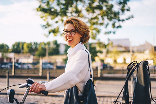 Frau auf Fahrrad genießt flexible Arbeitszeiten draußen