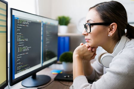 Programmiererin beschäftigt sich mit .htaccess-Datei am Computer