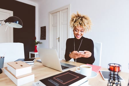 Frau am Smartphone im Buero beim Influencer anschreiben