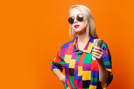 Influencerin hält Geld in der Hand symbolisierend für Influencer-Marketing-Kosten
