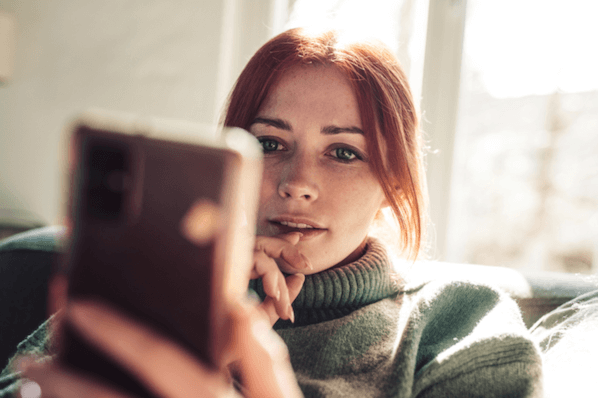 Frau plant Instagram-Post am Smartphone