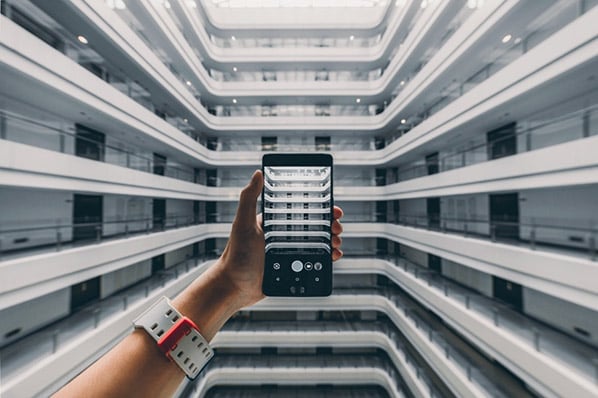 Person hält Smartphone in Hand innerhalb eines Gebäudes