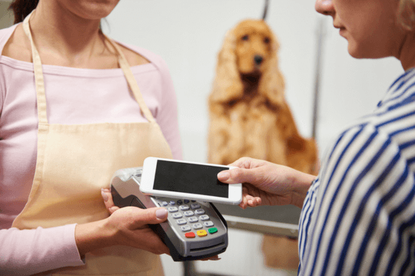 Kundin nutzt Kundenbindungsprogramm indem sie mit dem Smartphone bei Verkäuferin zahlt