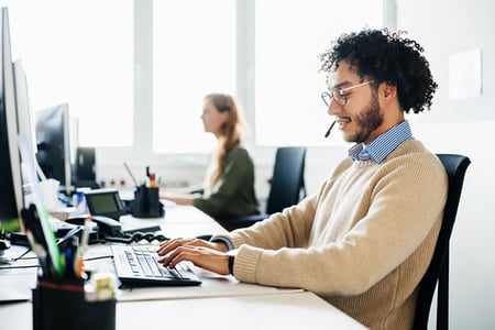 Mitarbeiter sitzt vor PC und schreibt Kundenservice-E-Mail-Vorlage
