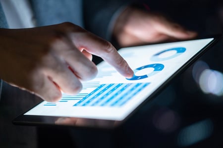 Finger auf Tablet mit Grafiken zu Leadqualität aus Ads