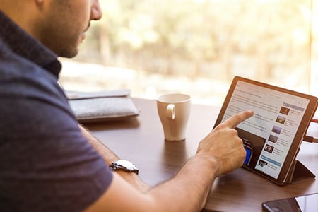Mann vor Tablet erstellt LinkedIn-Gruppe per Touchscreen