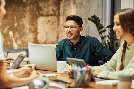 Mitarbeitende bei Meeting nutzen MarTech auf Laptops