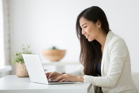 Frau schreibt Meta Description am Laptop
