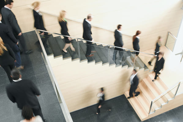 Mitarbeitende gehen die Treppe herunter als Symbol einer Mitarbeiterfluktuation