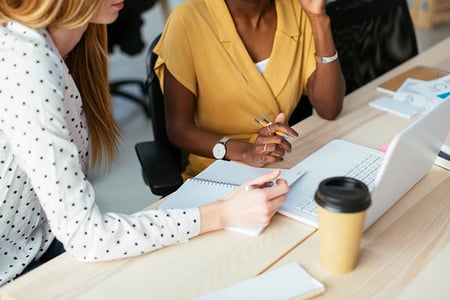 Frauen koordinieren Newsletter-Versand im Büro
