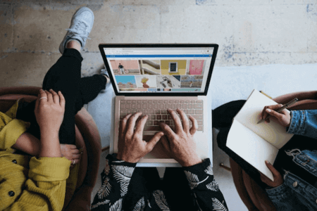 Team sucht nach passenden Online-Marketing-Kanälen am Laptop