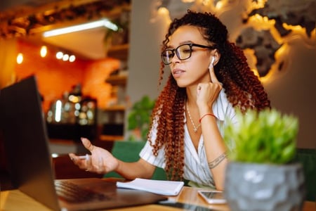 Frau sitzt am Laptop und nimmt an einem Online-Marketing-Kurs teil