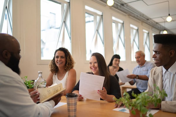 Gruppe von Personal sitzt am Tisch und spricht über Personalentwicklung