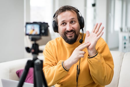 Mann filmt zuhause mit Kamera Videos mit verkaufspsychologischen Techniken