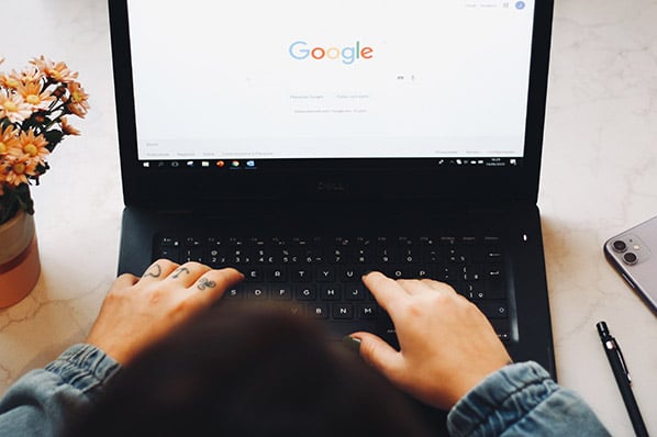 Person vor Laptop nutzt Google um Responsive Search Ads zu sehen