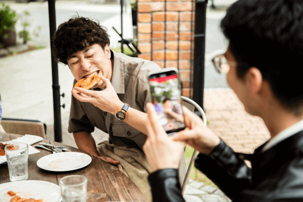 Personen nehmen Video mit Smartphone auf für Restaurant-Marketing