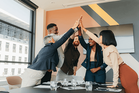 Team freut sich über effektiven Sales-Enablement-Content und gibt sich High Five