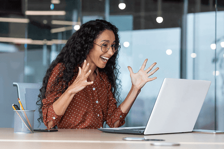 Hispanisch aussehende Frau freut sich ueber Ihren Erfolg beim Social Selling