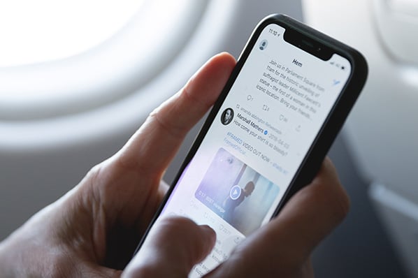 Person nutzt Twitter Cards am Smartphone