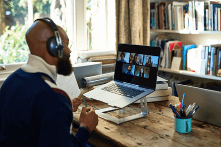 Mann vor Laptop nimmt an Webinar über Webinar-Software teil
