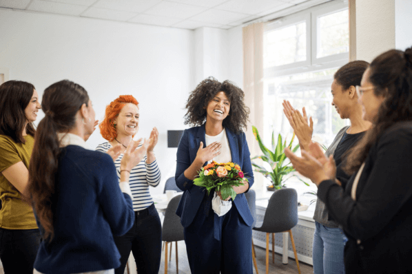 Frauen stehen im Büro und zeigen Kollegin Wertschätzung