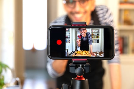 Mann erstellt Bild für YouTube-Banner mit Smartphone