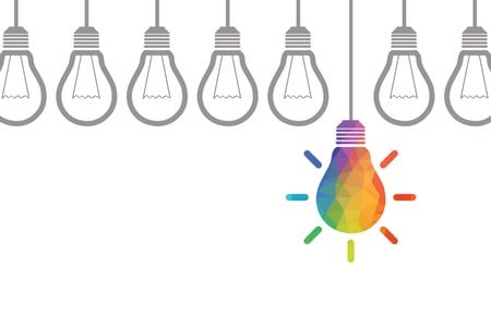 Grafik Regenbogenfarbige Glühbirne hängt neben nicht farbigen Glühbirnen