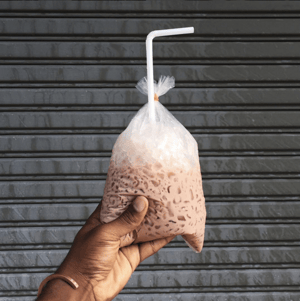 Eisgekühltes-Kakaogetränk-im-Plastikbeutel.png HubSpot-Handyfoto eines eisgekühlten Kakaogetränks im Plastikbeutel mit Strohhalm