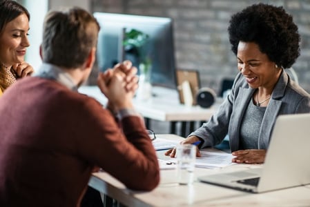 Personen sitzen zusammen am Tisch und beschäftigen sich mit Managed Services