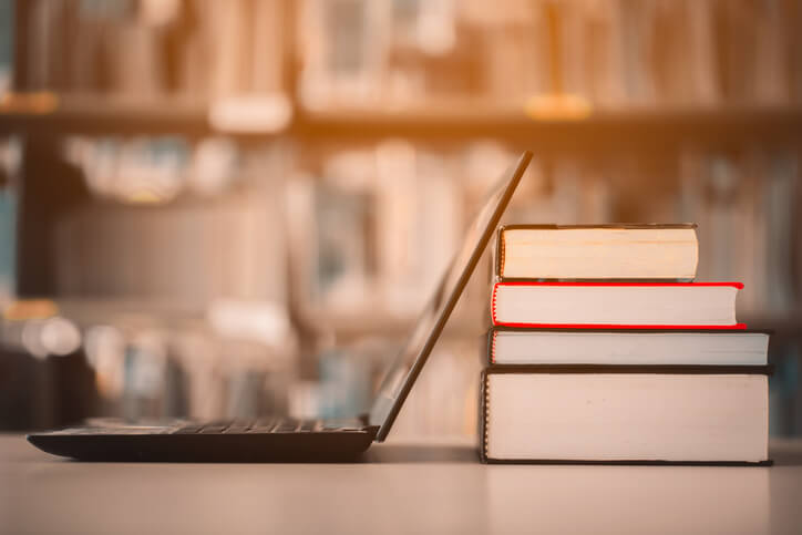Laptop vor Büchern symbolisiert die Geschichte des Internets