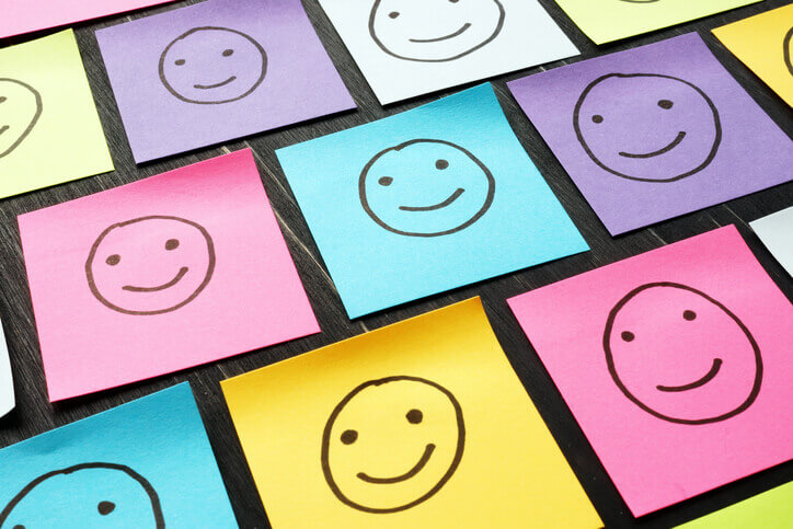 Verschieden farbige Post-Its mit Smiley-Gesichtern