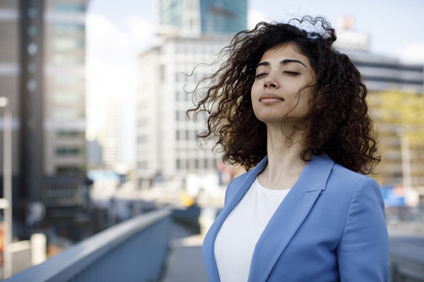 Entspannte Businessfrau mit Augen denkt über Eustress und Distress nach