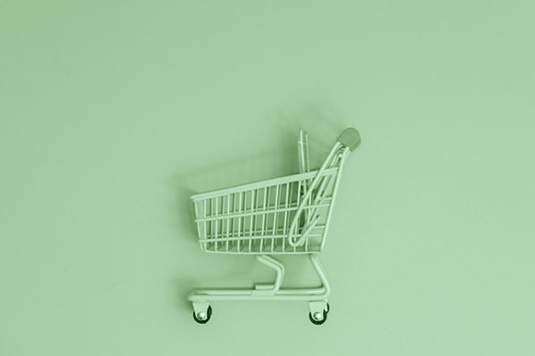 Einkaufswagen auf grünem Hintergrund symbolisiert Nachhaltigkeit im E-Commerce