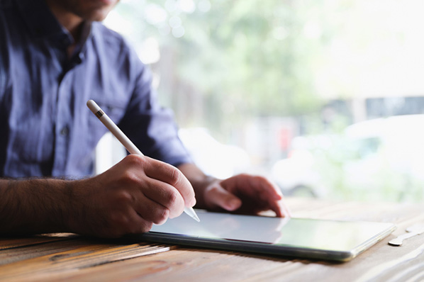 Mann am Tablet mit Stift unterschreibt Smart Contracts