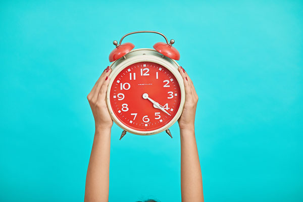 Marketer hält eine Uhr: Wann ist die beste Zeit, auf Social Media zu posten?